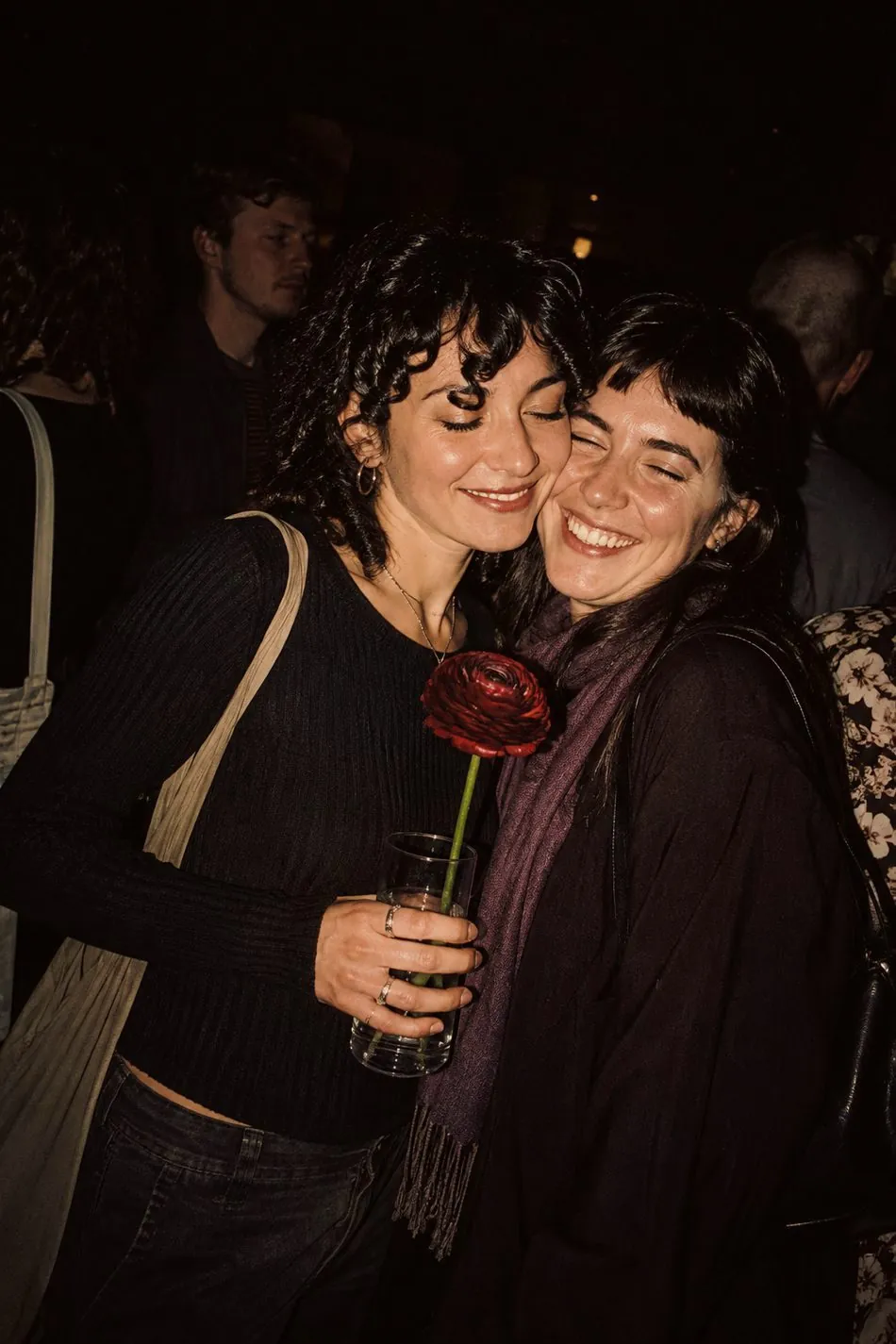 Two people embracing at an evening gathering